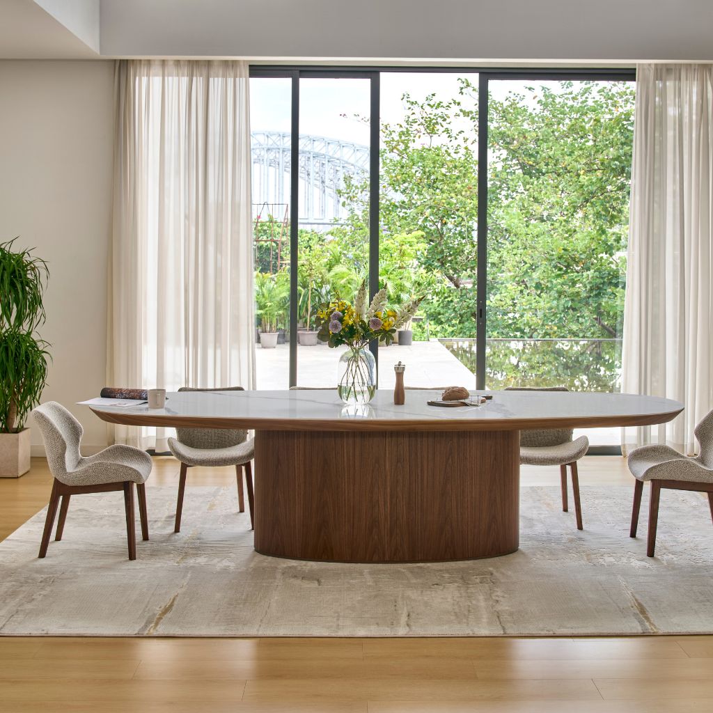 Ava Oval Dining Table with a Bianco ceramic top and sculptural timber base