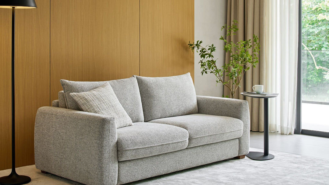 Nadia Sofa Bed in light grey textured fabric against a timber-panelled wall
